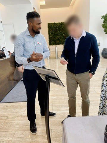 Tino Jalo talking a guest through a wellbeing stand in an office lobby